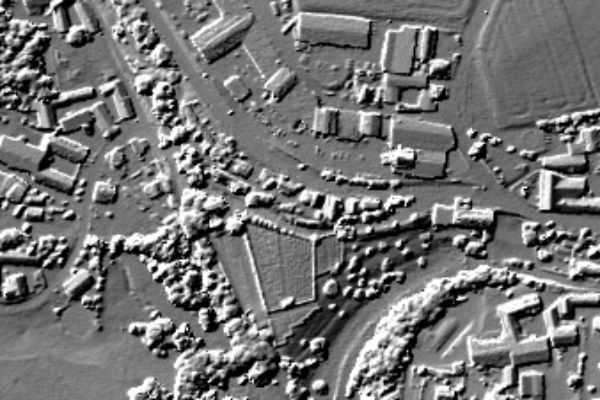 Das Bild zeigt ein Geländerelief, aber im Gegensatz zum Höhenraster werden hier auch Gebäude und die Vegetation dargestellt.